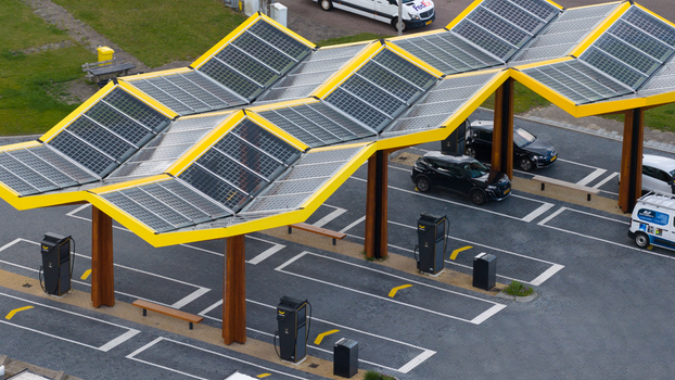Oostzaan Noord Holland Netherlands 09 June 2026 Aerial view of Fastned Charging Station with solar panel canopy electric vehicles parked at charging points and wooden support pillars.