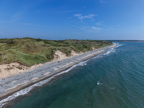 Aerial view of the sandy coastline and grassy dunes of Murlough Beach meeting the sea in Newcastle Northern Ireland United Kingdom. Aerial view of the sandy coastline and grassy dunes of Murlough Beach meeting the sea in Newcastle Northern Ireland United Kingdom.