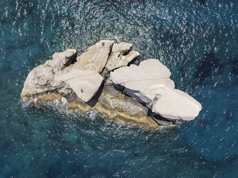 Aerial view of white volcanic rock formations surrounded by deep blue Aegean Sea waters in Milos Greece. Aerial view of white volcanic rock formations surrounded by deep blue Aegean Sea waters in Milos Greece.