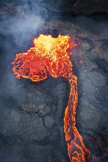Aerial view of fiery rivers of molten lava cutting through the dark textured earth a stark contrast of destruction and raw beauty Reykjavik Reykjanes Iceland.