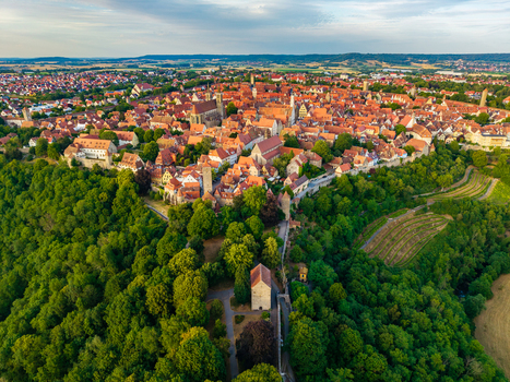 Aerial view of Rothenburg ob der Tauber featuring its historic medieval architecture red tiled rooftops and surrounding lush green forests in Rothenburg ob der Tauber Bavaria Germany. Aerial view of Rothenburg ob der Tauber featuring its historic medieval architecture red tiled rooftops and surrounding lush green forests in Rothenburg ob der Tauber Bavaria Germany.