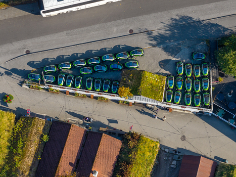 Aerial view of small electric rental cars parked in a lot with a green roof in Geiranger More og Romsdal Norway.