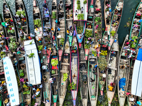 Rangamati Hill District Bangladesh 18 May 2024 Aerial view of Kaptai Lake with traditional wooden boats laden with fresh produce and local traders navigating the busy waterway.