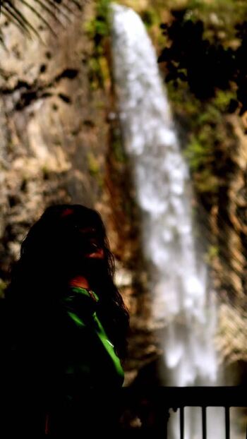 View of a person admiring a waterfall New Zealand.