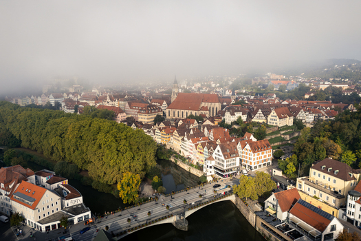 Aerial view of the historic old town of Tubingen with the Stiftskirche and Neckar river under morning fog Tubingen Baden Wurttemberg Germany. Aerial view of the historic old town of Tubingen with the Stiftskirche and Neckar river under morning fog Tubingen Baden Wurttemberg Germany.