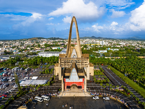 Aerial view of the Basilica Nuestra Senora De La Altagracia with its iconic arch surrounded by parking lots and the urban landscape of Higuey La Altagracia Province Dominican Republic. Aerial view of the Basilica Nuestra Senora De La Altagracia with its iconic arch surrounded by parking lots and the urban landscape of Higuey La Altagracia Province Dominican Republic.