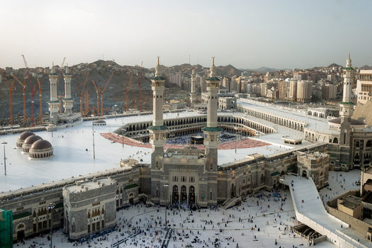 Aerial view of Masjid al Haram with its minarets the Kaaba in the courtyard expansive white marble prayer areas and construction cranes in Makkah Makkah Province Saudi Arabia. Aerial view of Masjid al Haram with its minarets the Kaaba in the courtyard expansive white marble prayer areas and construction cranes in Makkah Makkah Province Saudi Arabia.