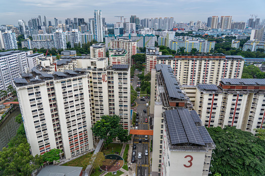 Aerial view of high rise HDB residential apartment blocks featuring rooftop solar panels lush greenery and urban streets in Singapore Singapore. Aerial view of high rise HDB residential apartment blocks featuring rooftop solar panels lush greenery and urban streets in Singapore Singapore.