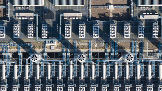 Aerial view of the industrial rooftop featuring rows of HVAC cooling units complex ventilation pipes and technical infrastructure in Dietzenbach Hessen Germany. Aerial view of the industrial rooftop featuring rows of HVAC cooling units complex ventilation pipes and technical infrastructure in Dietzenbach Hessen Germany.