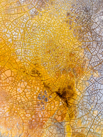 Aerial view of a cracked textured surface of dried earth with intricate patterns in shades of yellow orange and grey in Andalusia Spain. Aerial view of a cracked textured surface of dried earth with intricate patterns in shades of yellow orange and grey in Andalusia Spain.