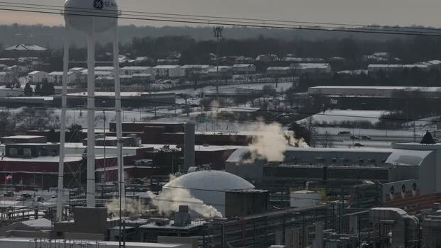 Aerial view of GE Aerospace plant with steam rising in winter United States. Aerial view of GE Aerospace plant with steam rising in winter United States.