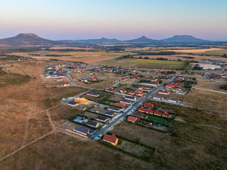 Aerial view of Tapolca residential area in Veszprem County Hungary with modern houses roads and surrounding fields in the Balaton region at sunset in summer. Aerial view of Tapolca residential area in Veszprem County Hungary with modern houses roads and surrounding fields in the Balaton region at sunset in summer.