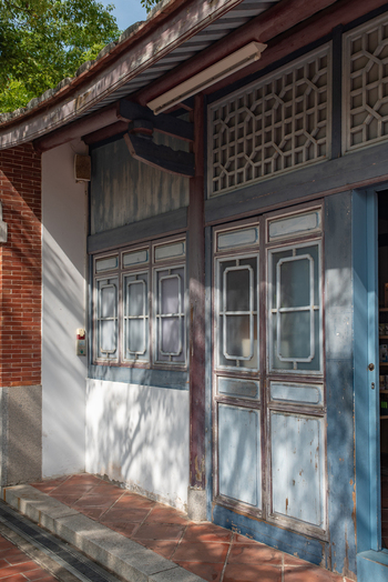 View of the traditional architecture at Chihkan Tower featuring intricate wooden window frames blue painted doors and red brick flooring in Chihkan Village Tainan City Taiwan. View of the traditional architecture at Chihkan Tower featuring intricate wooden window frames blue painted doors and red brick flooring in Chihkan Village Tainan City Taiwan.