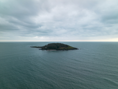 Aerial view of Looe Island surrounded by the sea under an overcast sky in Looe Cornwall United Kingdom. Aerial view of Looe Island surrounded by the sea under an overcast sky in Looe Cornwall United Kingdom.