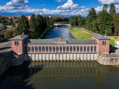 Aerial view of the historic Canale Cavour intake structure with its red brick facade and arched windows over the water Chivasso Piedmont Italy.