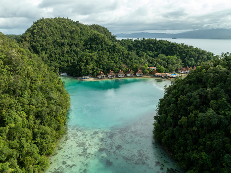 Aerial view of Bucas Grande featuring a turquoise lagoon surrounded by lush tropical forests and small wooden cottages along the shoreline in Siargao Philippines. Aerial view of Bucas Grande featuring a turquoise lagoon surrounded by lush tropical forests and small wooden cottages along the shoreline in Siargao Philippines.