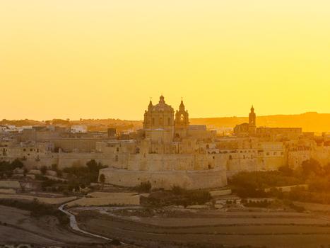 Aerial view of the historic fortified city of Mdina with its cathedral dome and stone walls glowing under the warm light of sunset Mdina Malta. Aerial view of the historic fortified city of Mdina with its cathedral dome and stone walls glowing under the warm light of sunset Mdina Malta.