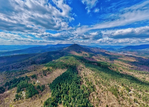 Aerial view of the lush undulating landscape where the verdant forests meet the sky under the scattered clouds Kintzheim Grand Est France.
