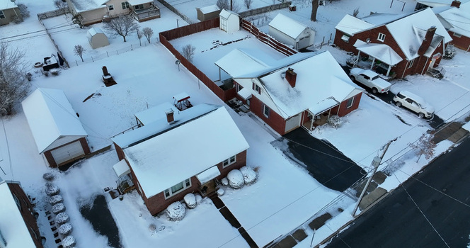 Aerial view of residential houses with snow covered roofs and driveways in a quiet neighborhood in Lititz Pennsylvania United States.