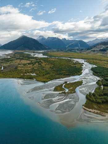 Aerial view of braided rivers carving paths through the landscape where turquoise waters meet rugged mountain peaks Glenorchy Otago Region New Zealand. Aerial view of braided rivers carving paths through the landscape where turquoise waters meet rugged mountain peaks Glenorchy Otago Region New Zealand.