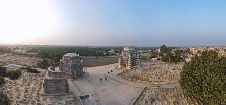Aerial view of the historic blue tiled shrines and tombs surrounded by an ancient cemetery and arid landscape in Uch Sharif Punjab Pakistan. Aerial view of the historic blue tiled shrines and tombs surrounded by an ancient cemetery and arid landscape in Uch Sharif Punjab Pakistan.