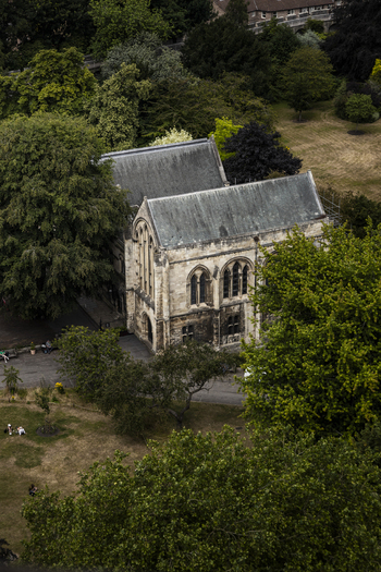 Aerial view of the historic stone ruins of St. Marys Abbey surrounded by lush green trees and parkland in York England United Kingdom.