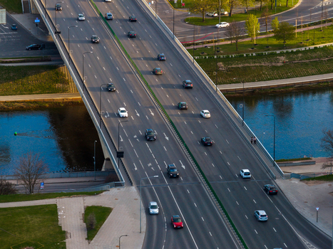 Aerial view of a multi lane bridge crossing a river with traffic and green banks in Vilnius County Lithuania. Aerial view of a multi lane bridge crossing a river with traffic and green banks in Vilnius County Lithuania.