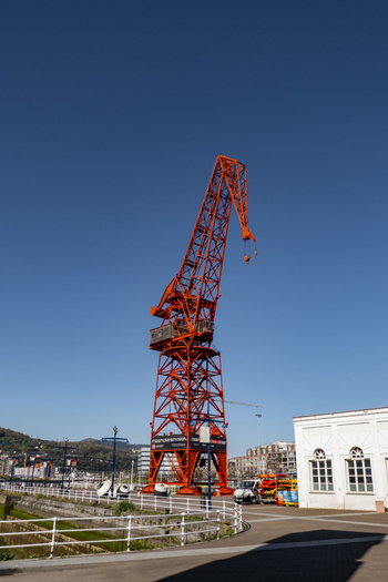 View of the historic red Carola Crane at the maritime museum dock under a clear blue sky in Greater Bilbao Basque Country Spain. View of the historic red Carola Crane at the maritime museum dock under a clear blue sky in Greater Bilbao Basque Country Spain.