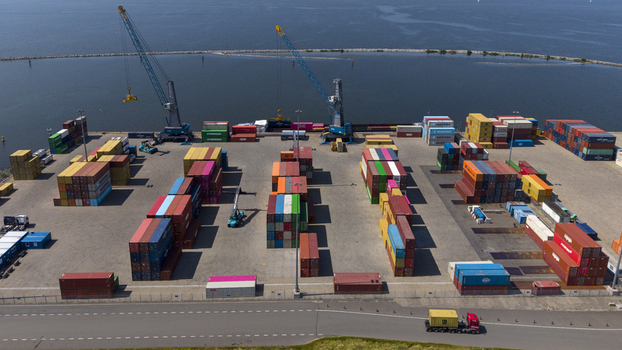 Aerial view of TMA Terminals Lelystad featuring rows of colorful shipping containers large cranes and a truck driving along the perimeter in Lelystad Flevoland Netherlands. Aerial view of TMA Terminals Lelystad featuring rows of colorful shipping containers large cranes and a truck driving along the perimeter in Lelystad Flevoland Netherlands.