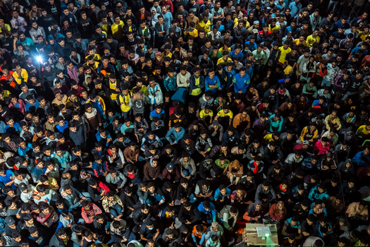 Bogura Rajshahi Division Bangladesh 28 November 2022 View of a large crowd of people gathered at night illuminated by a projector screen.