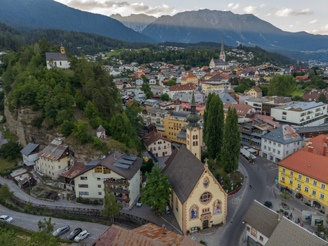Aerial view of the town of Imst with its historic church traditional alpine architecture and lush mountain valley backdrop in Imst Tyrol Austria.