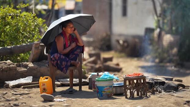 View of a woman sitting under an umbrella in Surkhet Nepal.