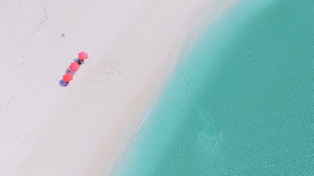 Aerial view of red umbrellas on a white sand beach in Vashafaru Maldives. Aerial view of red umbrellas on a white sand beach in Vashafaru Maldives.