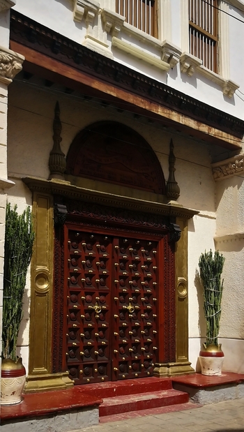 View of a traditional carved wooden door with brass studs in Stone Town Zanzibar Mjini Magharibi Regio Tanzania. View of a traditional carved wooden door with brass studs in Stone Town Zanzibar Mjini Magharibi Regio Tanzania.