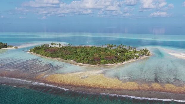Aerial view of a tropical island and coral reefs Maldives.