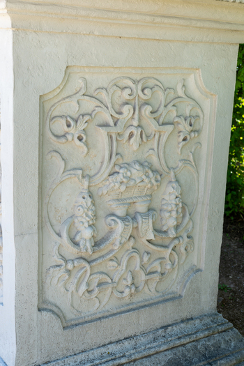 View of intricate stone relief carving featuring floral and scroll motifs on a pedestal at Belvedere Palace in Vienna Austria. View of intricate stone relief carving featuring floral and scroll motifs on a pedestal at Belvedere Palace in Vienna Austria.
