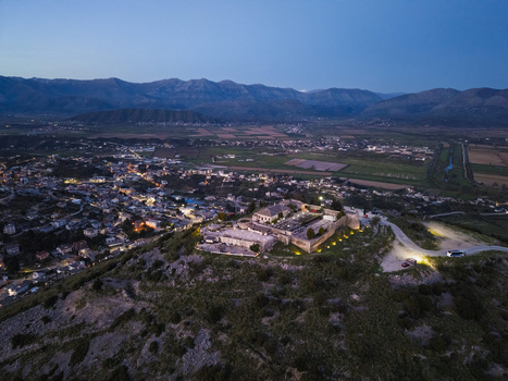 Aerial view of Lekuresi Castle illuminated at dusk overlooking the coastal town of Saranda Vlore County Albania. Aerial view of Lekuresi Castle illuminated at dusk overlooking the coastal town of Saranda Vlore County Albania.