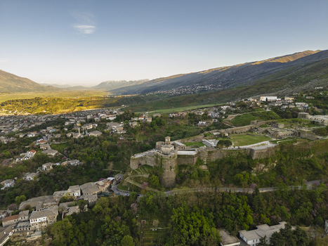 Aerial view of Gjirokaster Fortress surrounded by historic stone houses and lush greenery in the old town of Gjirokaster Gjirokaster County Albania. Aerial view of Gjirokaster Fortress surrounded by historic stone houses and lush greenery in the old town of Gjirokaster Gjirokaster County Albania.