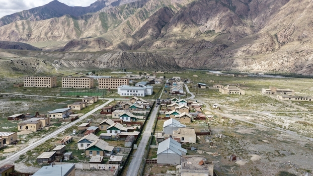 Aerial view of the remote village of Ak Su near the Engilchek Glacier featuring Soviet era apartment blocks small houses and rugged mountain terrain in Ak Su Issyk Kul Region Kyrgyzstan. Aerial view of the remote village of Ak Su near the Engilchek Glacier featuring Soviet era apartment blocks small houses and rugged mountain terrain in Ak Su Issyk Kul Region Kyrgyzstan.