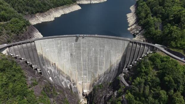 Lavertezzo Switzerland 19 May 2026 Aerial view of the Verzasca Dam nestled between steep rocky cliffs and lush green forests with a calm reservoir behind it.