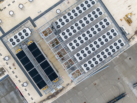 Aerial view of ai data center cooling system with rows of industrial fans and heat exchangers on a flat rooftop in Krakow Lesser Poland Voivode Poland. Aerial view of ai data center cooling system with rows of industrial fans and heat exchangers on a flat rooftop in Krakow Lesser Poland Voivode Poland.