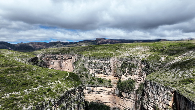 Aerial view of El Vergel canyon featuring steep rock walls lush green vegetation and a winding trail in Torotoro Potosi Department Bolivia. Aerial view of El Vergel canyon featuring steep rock walls lush green vegetation and a winding trail in Torotoro Potosi Department Bolivia.