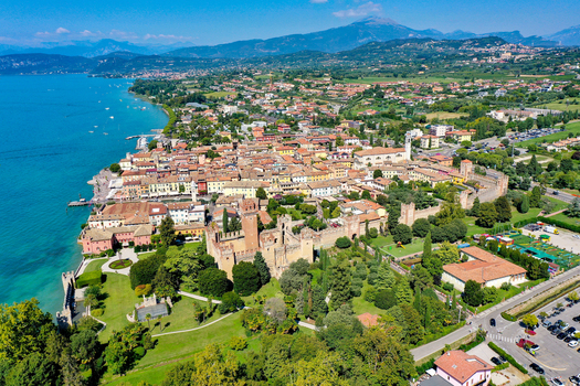 Aerial view of the Scaligero Castle and the historic town of Lazise on the shores of Lake Garda with medieval walls and lush gardens Provincia di Verona Veneto Italy.