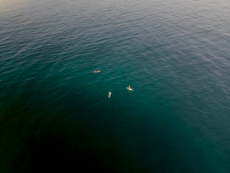 Aerial view of people on paddleboards and a small boat in the turquoise Mediterranean Sea Sitges Catalonia Spain. Aerial view of people on paddleboards and a small boat in the turquoise Mediterranean Sea Sitges Catalonia Spain.