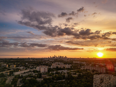 Aerial view of the Warsaw city skyline with skyscrapers and residential apartment blocks under a dramatic sunset sky in Poland. Aerial view of the Warsaw city skyline with skyscrapers and residential apartment blocks under a dramatic sunset sky in Poland.