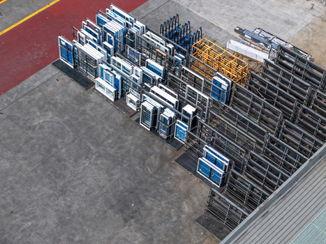 Melbourne VIC Australia 25 September 2026 Aerial view of a storage yard filled with rows of window frames and industrial metal racks on a concrete surface.