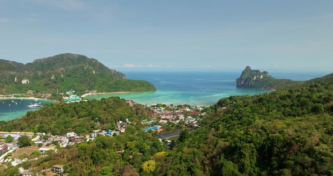 Aerial view of the lush green hills and coastal landscape surrounding a bay with turquoise water and small boats in Phuket Phuket Thailand. Aerial view of the lush green hills and coastal landscape surrounding a bay with turquoise water and small boats in Phuket Phuket Thailand.