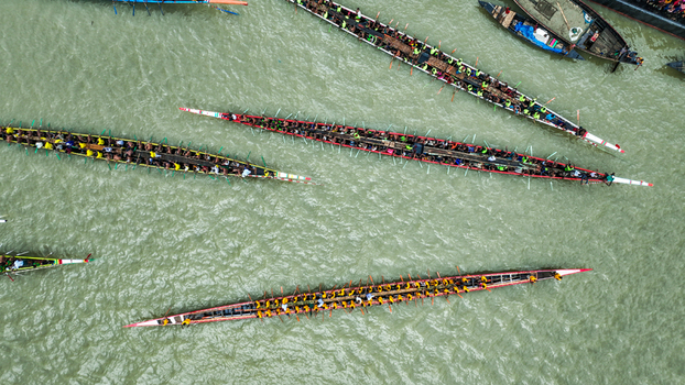 Baghabari Bangladesh 20 August 2022 Aerial view of traditional long racing boats filled with rowers navigating the river during a competitive race.
