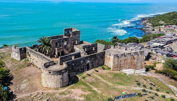 Aerial view of the historic Fort Amsterdam stone fortress situated on a coastal cliff overlooking the turquoise sea in Ghana. Aerial view of the historic Fort Amsterdam stone fortress situated on a coastal cliff overlooking the turquoise sea in Ghana.
