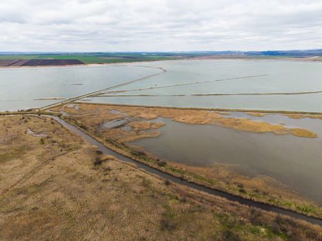 Aerial view of Lake Atanasovsko featuring salt pans narrow dikes and dry reeds under a cloudy sky in Burgas Burgas Bulgaria. Aerial view of Lake Atanasovsko featuring salt pans narrow dikes and dry reeds under a cloudy sky in Burgas Burgas Bulgaria.